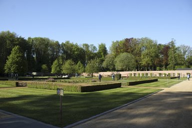 Photo des participants se promenant dans les jardins du Château de Jehay. Il fait beau.
