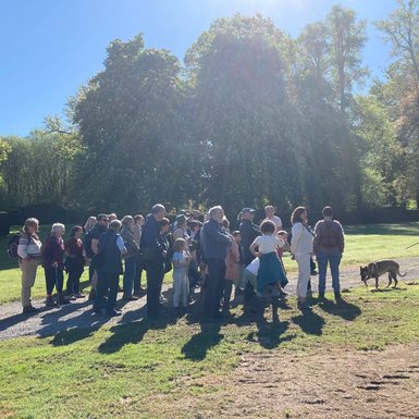 Photo des participants en groupe, environ une trentaine de personnes dont des adultes et des enfants, dans le jardin du château. 