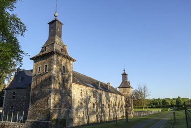 Photo du Château de Jehay sur un ciel bleu sans nuage.
