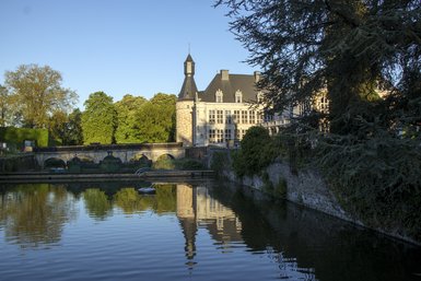 Photo du Château de Jehay avec l'eau en avant plan.