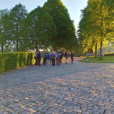 Photo des participants en groupe devant l'allée d'entrée du Château de Modave. Ils sont baignés des rayons du soleil du petit matin.